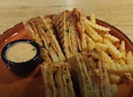 Chicken Teriyaki Sandwich with crinkle fries and dip on a terracotta plate