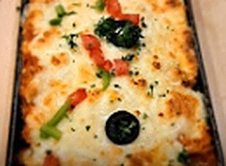 Chicken Lasagna baked and served in a black dish at Second Cup Johar Town