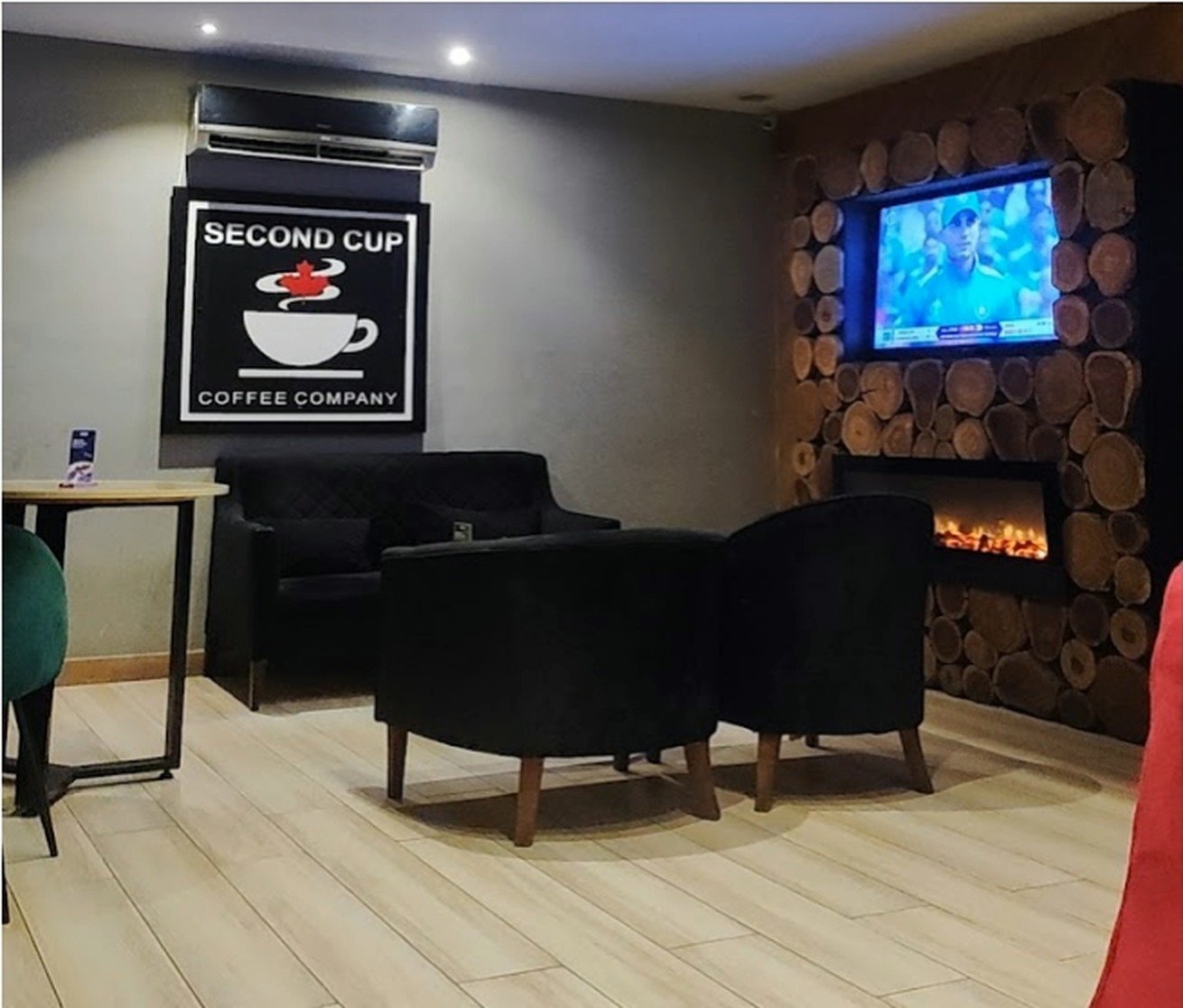 Fireplace lounge with black armchairs and Second Cup artwork