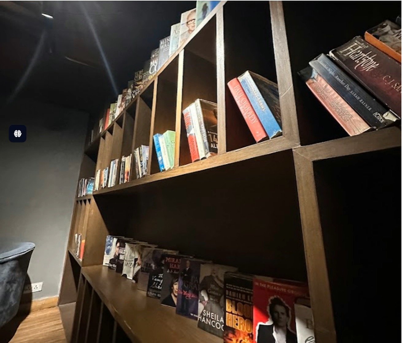 Tall wooden bookshelf filled with novels at Second Cup Johar Town