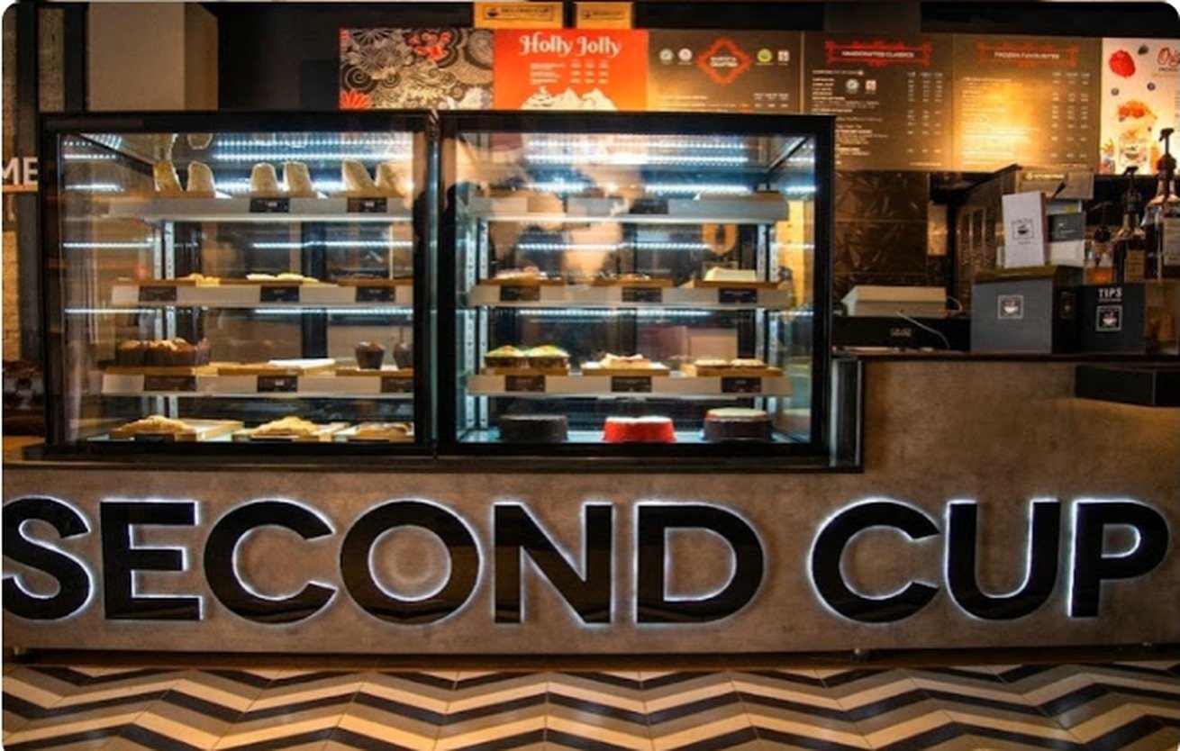 Lit patisserie display case above the SECOND CUP counter signage