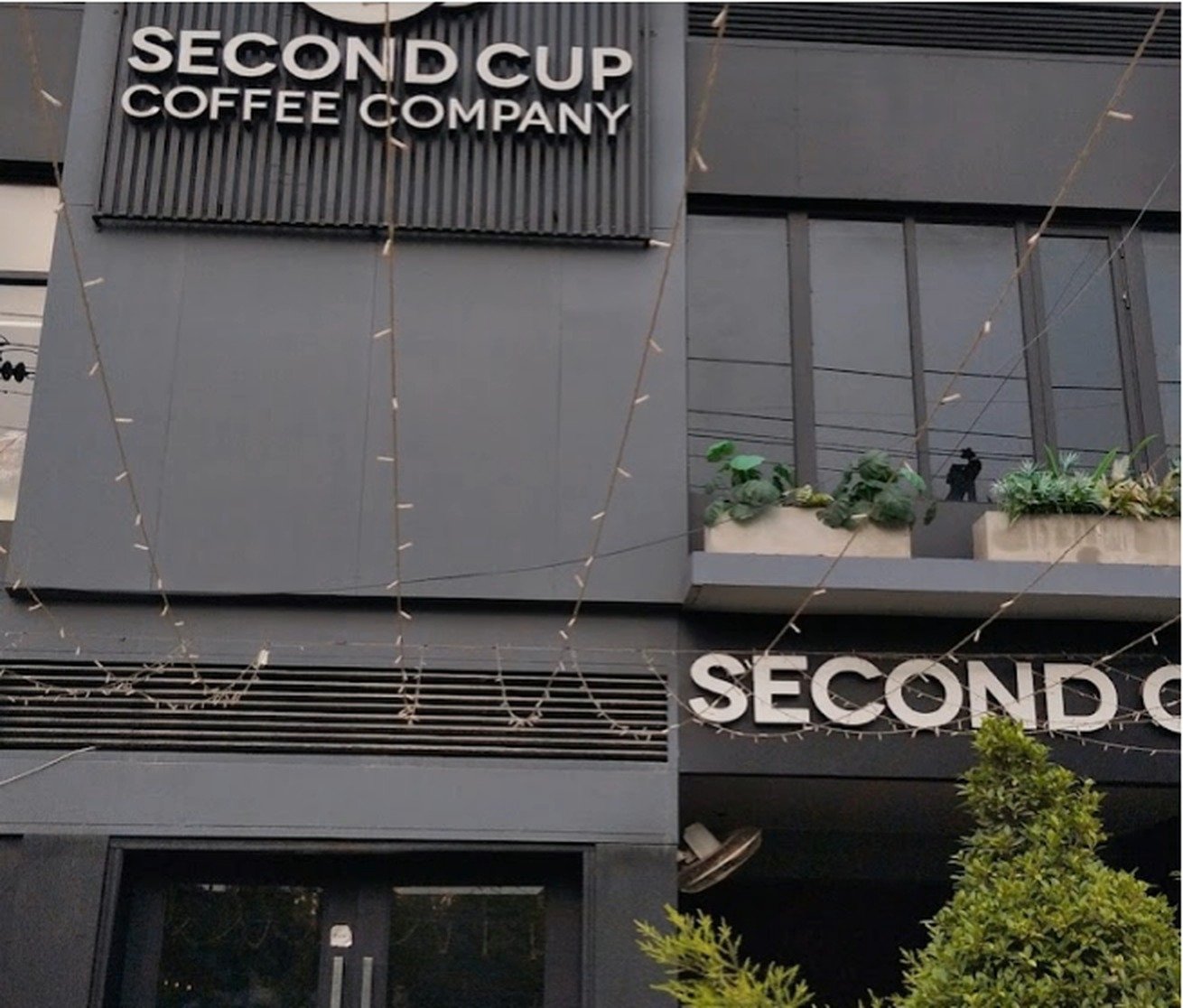 Second Cup Coffee Company signage on the Abdul Haque Road building at dusk
