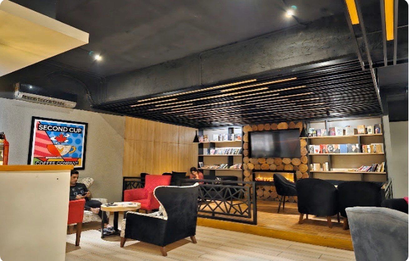 Red and black wingback armchairs beneath the Second Cup Coffee Company artwork