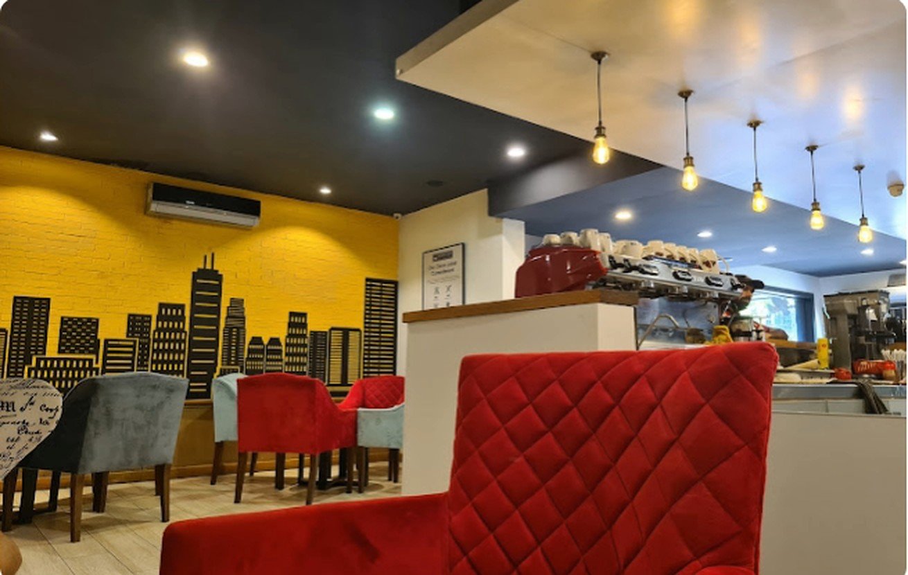 Yellow skyline mural wall with red velvet seating beside the service counter