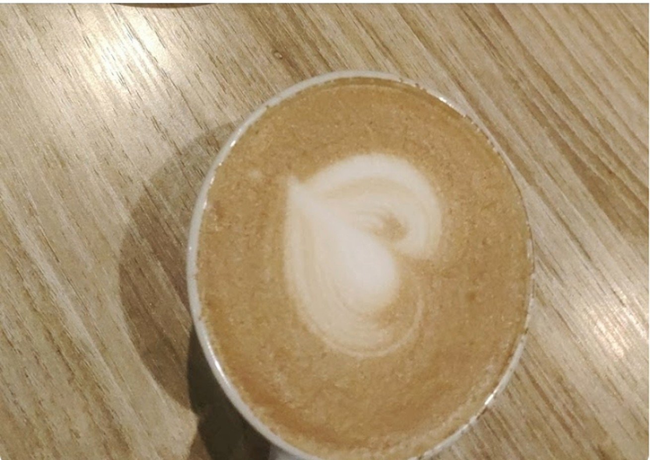 Latte with heart-shaped rosetta art on a wooden table
