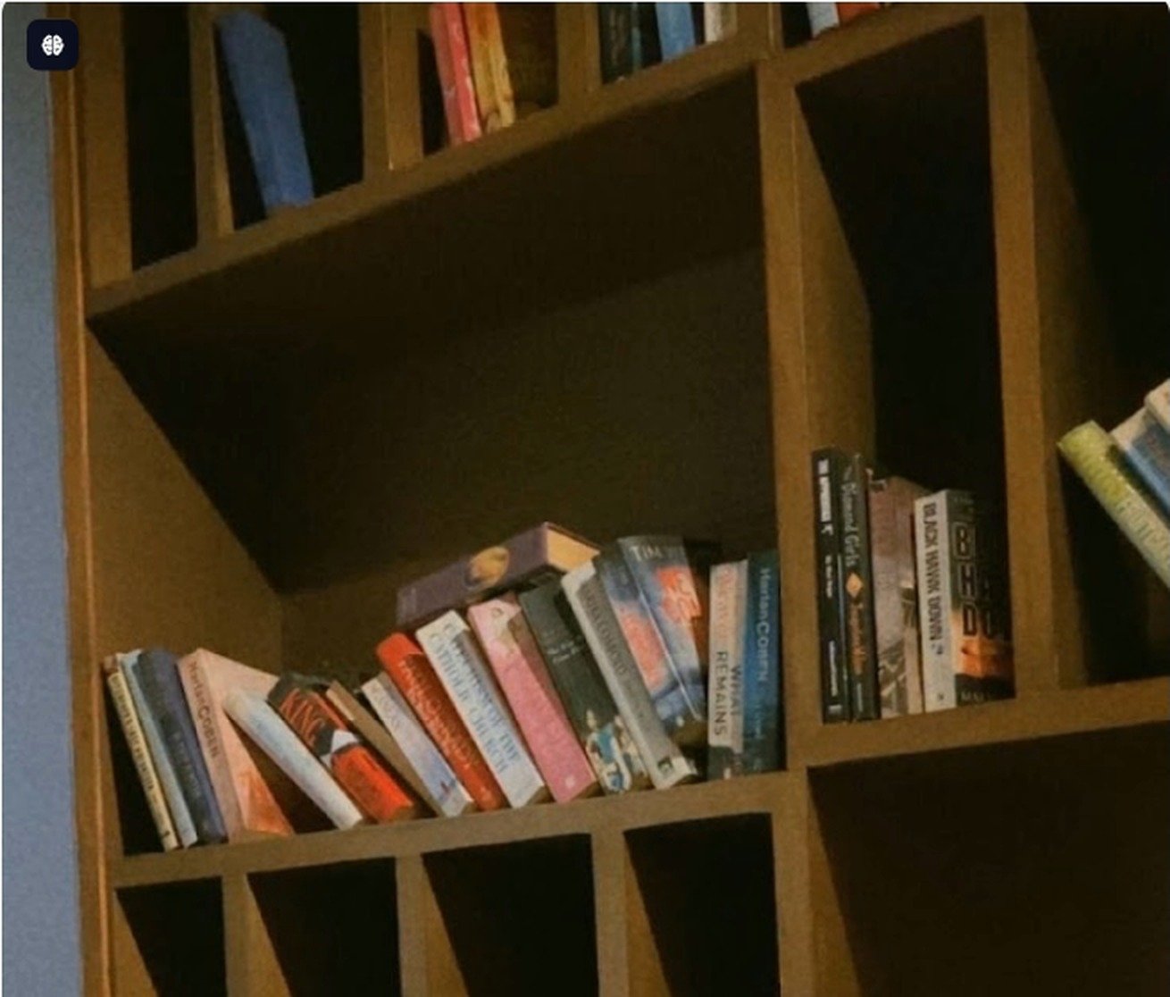 Wooden bookshelf stacked with novels inside Second Cup Johar Town