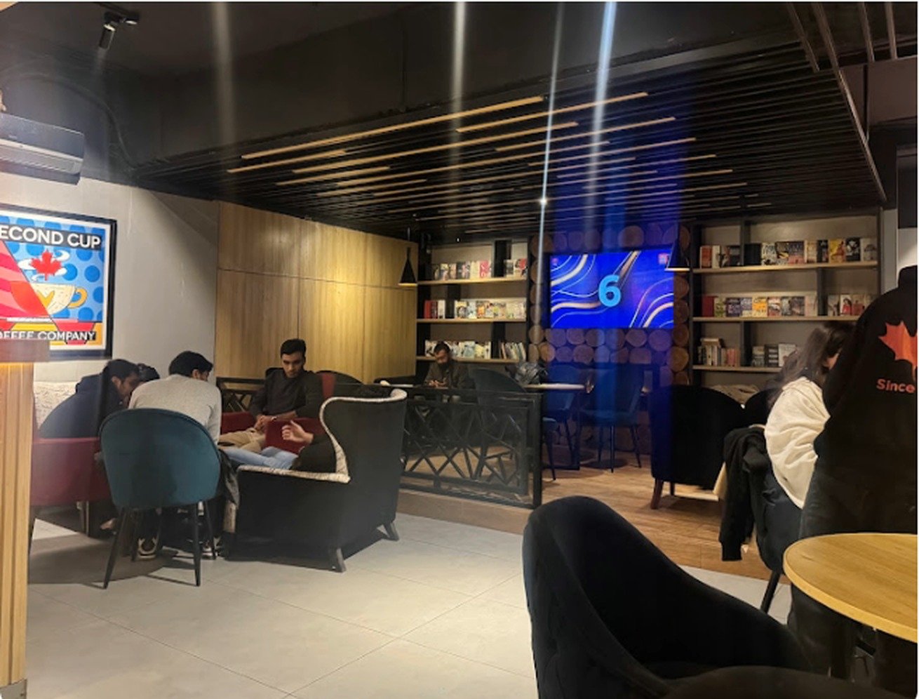 Guests seated in the wood-panelled lounge at Second Cup Johar Town