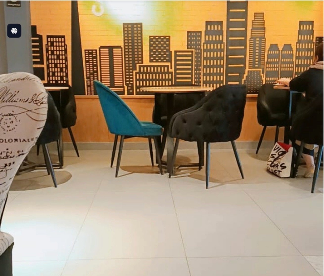 Skyline mural wall with velvet chairs inside Second Cup Johar Town